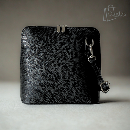 A black pebbled leather crossbody bag with a silver-tone metal frame clasp and a matching leather adjustable strap with a silver buckle, shown on a neutral gray background.