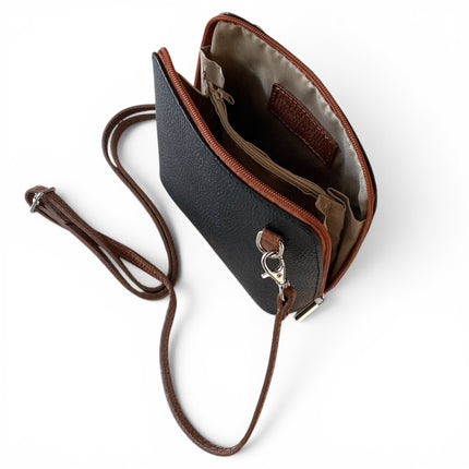 A two tone black and dark tan pebbled leather crossbody bag with brown leather trimmand silver-tone hardware, shown open on a white background.