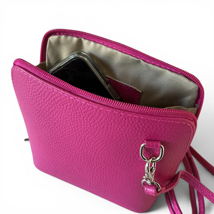 A bright fuchsia pebbled leather crossbody phone pouch shown open, containing a black smartphone. The bag features a silver-tone metal ring and clasp, a matching fuchsia strap, and a light beige interior lining, set against a plain white background.