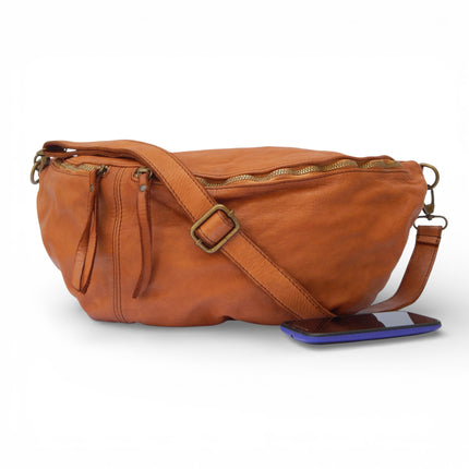 Brown leather bumbag bag with a phone on a white background