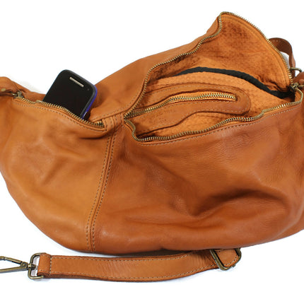 Brown leather bumbag handbag with a phone inside on a white background